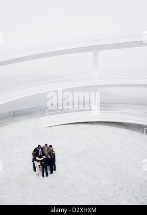 Business people meeting in huddle in courtyard Stock Photo