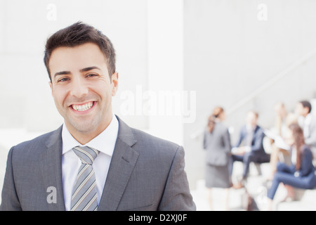 Portrait of smiling man with co-workers in background Stock Photo