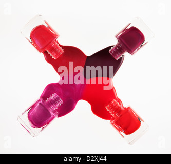 Multicolor fingernail polish spilling from bottles Stock Photo