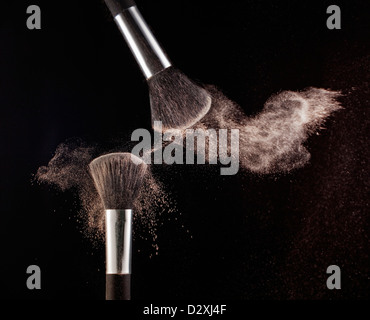 Powder blowing from makeup brushes Stock Photo