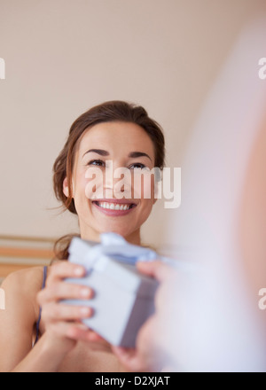 Smiling woman receiving gift from man Stock Photo