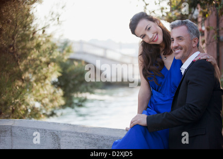 Portrait of smiling well-dressed couple at waterfront Stock Photo
