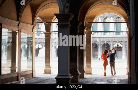 Couple dancing in archway in Venice Stock Photo