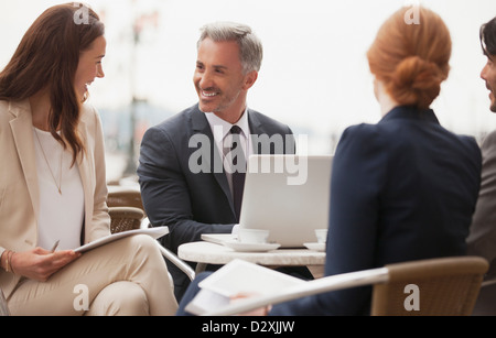 Smiling business people working at sidewalk cafe Stock Photo
