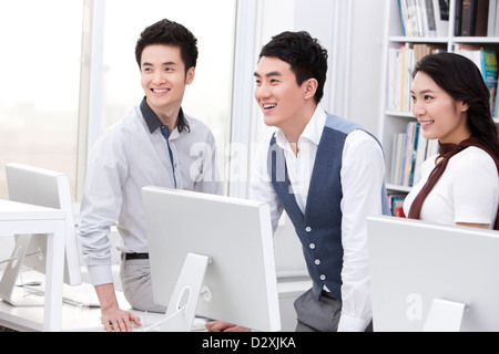 Cheerful office workers using computers in studio Stock Photo