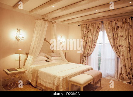 Sconces and canopy above bed in luxury bedroom Stock Photo