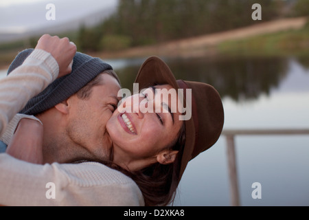Enthusiastic couple hugging at lakeside Stock Photo