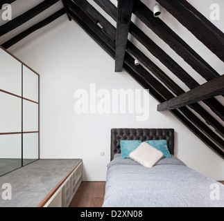 The Oaks, Richmond, United Kingdom. Architect: Soup Architects, 2012. Child's bedroom built into roof space with exposed beams. Stock Photo