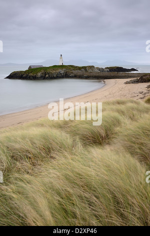 Grass covered sand dunes leading to the daymark on Llanddwyn Island, Anglesey, Wales. Stock Photo