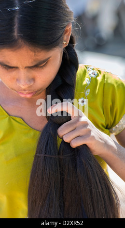 Rural Indian village girl plaiting her long hair. Andhra Pradesh, India Stock Photo