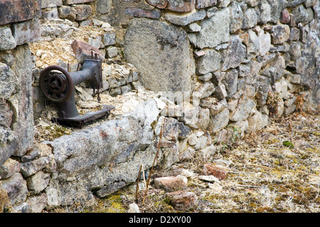 An old hand worked sewing machine in the remains of a ruined cottage in the destroyed the French village Oradour-sur-Glane. Stock Photo