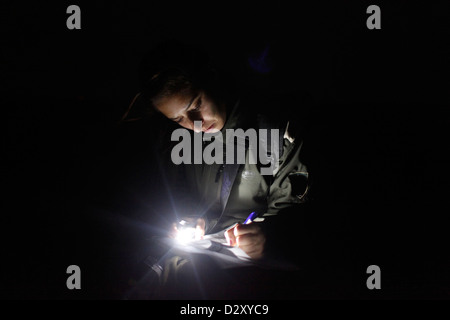 An Israeli female soldier from the 727th Eitam Field Intelligence Battalion of the Combat Intelligence Collection Corps writes a note during advance training at night close to the border with Egypt in the southern Negev desert Israel Stock Photo