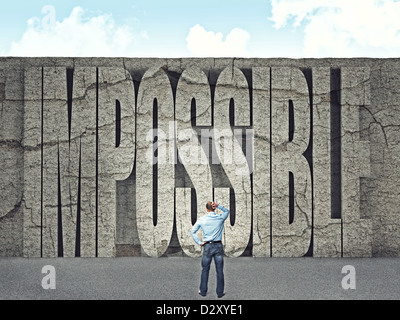 man look huge wall with impossible text Stock Photo