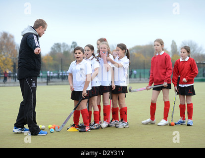 A games teacher instructs girls during hockey practice at Pates Grammar School in Cheltenham, Gloucestershire UK Stock Photo