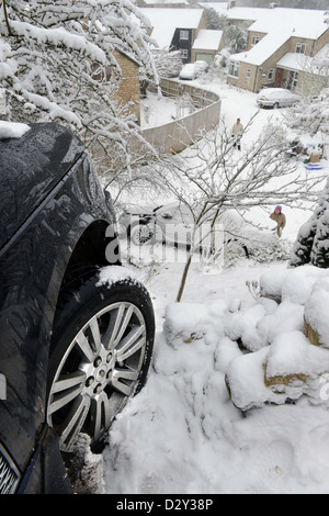 A Range Rover which hit a stationary Vauxhall after sliding in snow forcing it into gardens below on a hill known locally are 'T Stock Photo