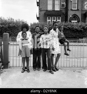 A family of British Afro-Caribbean siblings (Roper family) smiling posing children in 1970s Leeds West Yorkshire England UK. Their mother is pictured with the baby of the family in D2YA0M  1974 KATHY DEWITT Stock Photo