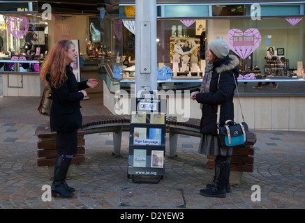 Two deaf Fingerspelling Jehovah Witnesses communicating using hand movements,  Canvassing in Blackpool, Lancashire, UK Stock Photo