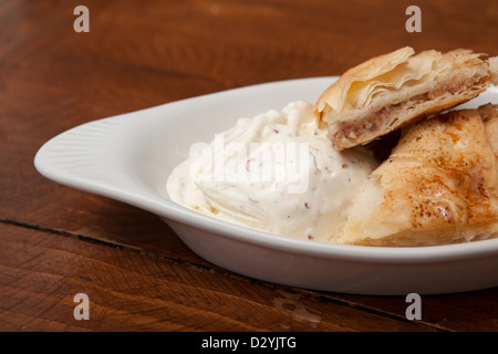 Side view of flaky delicious baklava served with a soft, home made ice cream Stock Photo