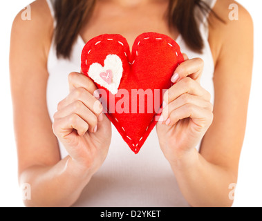 Picture of brunette woman holding red soft toy heart-shaped in hands, beautiful handmade present for Valentine day Stock Photo