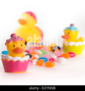 Easter rubber ducks with colorful jelly beans isolated on white background Stock Photo