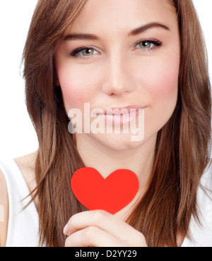 Photo of serious female holding in hand red heart-shaped greeting card, symbol of love, romantic message, Valentine day Stock Photo