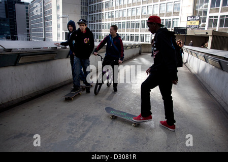 Urban youths hanging around with skateboards on a walkway in Waterloo, London, UK, a popular street culture gathering point. Stock Photo