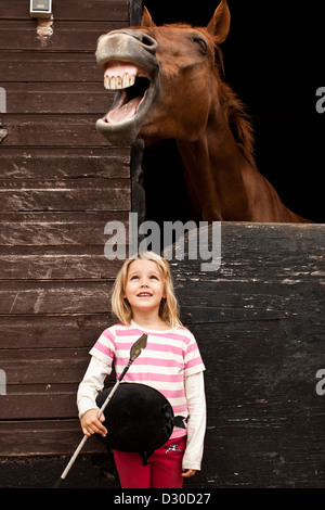 Young girl at stable door with pony in London, UK Stock Photo