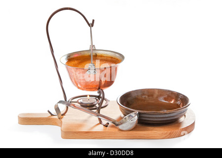 Goulash soup in a pot with ladle and plate on white background Stock Photo