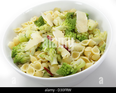 An Italian-style romanesco and pasta meal, cooked with chopped sun-dried tomatoes and topped with slivers of parmesan cheese Stock Photo