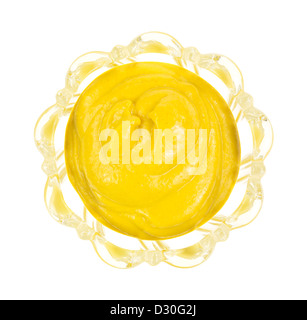 Top view of a leaded glass bowl filled with yellow mustard on a white background. Stock Photo