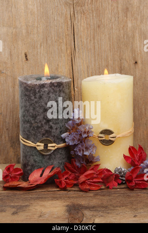 Two burning Feng Shui candles and potpourri on a background of weathered wood Stock Photo