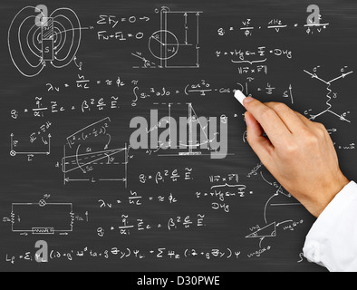 Research scientist writing physics diagrams and formulas with chalk on blackboard Stock Photo