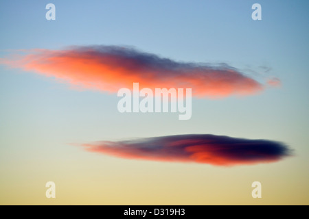 Two pink red lenticular clouds at sunset Stock Photo