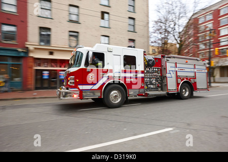 Vancouver fire rescue services truck engine 2 speeding through downtown city streets BC Canada deliberate motion blur Stock Photo