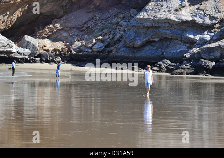 Woman strolls at low tide at the beach of Yiti; Muscat, Oman. Stock Photo