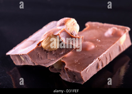 Two blocks of chocolate with nuts over black Stock Photo