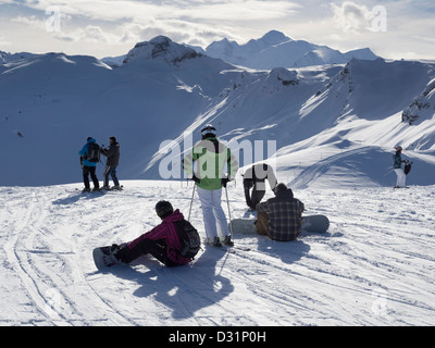 Skiers and snowboarders on piste in Le Grand Massif ski area with a view to Mont Blanc in French Alps. Grands Vans Flaine France Stock Photo