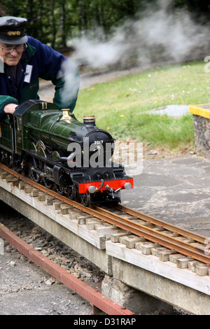 Man driving a miniature 4-6-0 steam locomotive Stock Photo