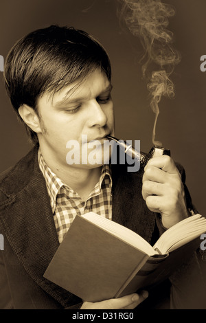 Portrait of a man reading and smoking a pipe. Close-up Stock Photo