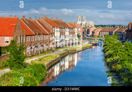 View of the beck, terrace houses, barges, and the Minster on a bright sunny day in summer, Beverley, Yorkshire, UK. Stock Photo