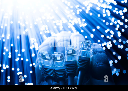 fiber optics and utp cables in hand shared concept Stock Photo