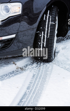 Car with winter tires drives on a road with snow cover. Stock Photo