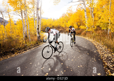 Caucasian cyclists on rural road Stock Photo