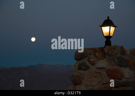 Death Valley National Park, California - A full moon sets over the Panamint Mountains at Stovepipe Wells Village. Stock Photo