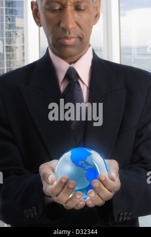 Mixed race businessman holding globe