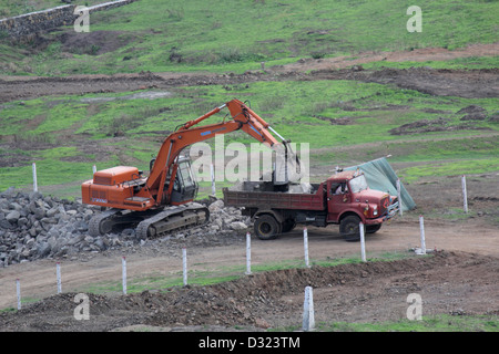 Excavator loading a truck with stones and road underlayment Stock Photo ...