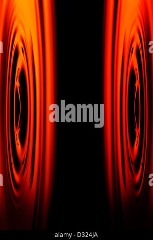 An abstract digital image featuring symmetrical, swirling patterns of vibrant red and orange hues on either side of a central black vertical strip. The patterns resemble concentric ripples or Stock Photo