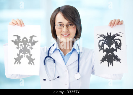 Smiling psychologist showing papers with Rorschach inkblots Stock Photo