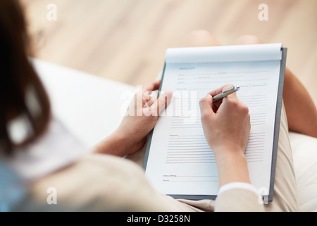 Female counselor writing down some information about her patient Stock Photo