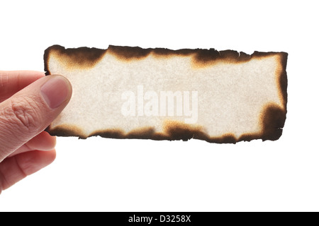 Hand holding piece of burned paper on white background. Stock Photo